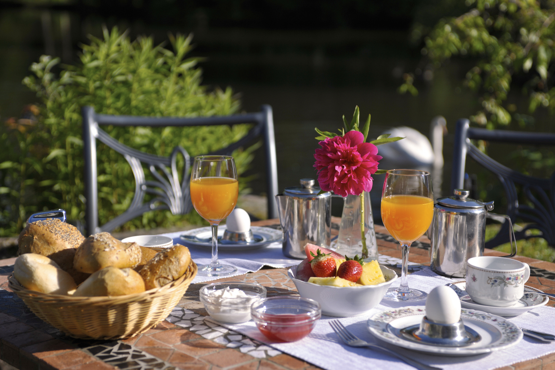 Frühstück mit Brötchen, Obst, Ei und Kaffee auf der Terrasse der Molitors Mühle